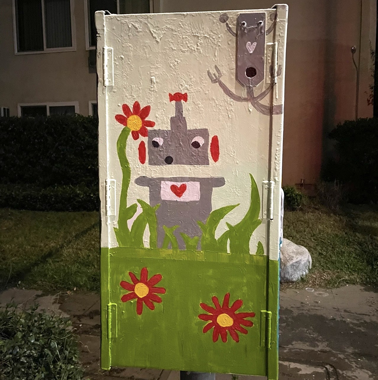 Robot standing among red flowers and green grass