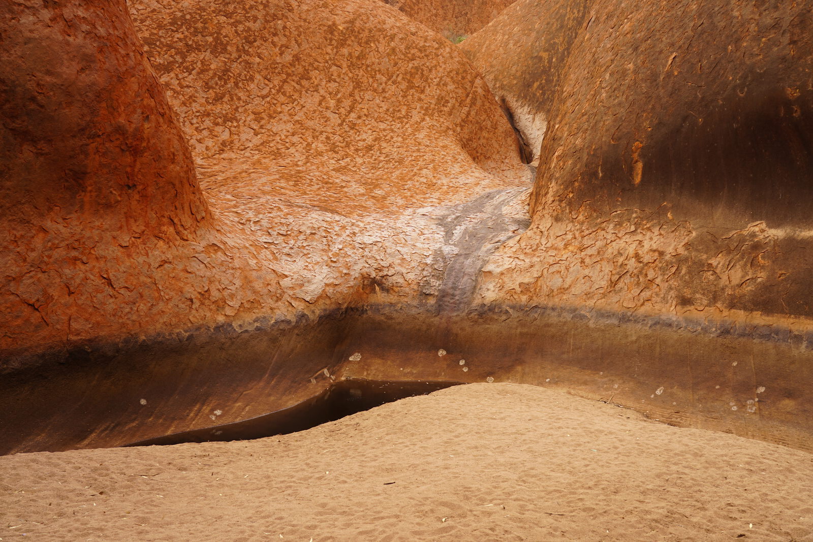 Rock face with watermark and sand